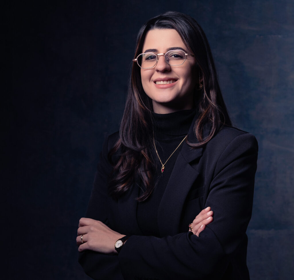 Dra Giovana Pellissari, vestida de preto, com sorriso e óculos de graus, realiza tratamentos para transtorno Bipolar.