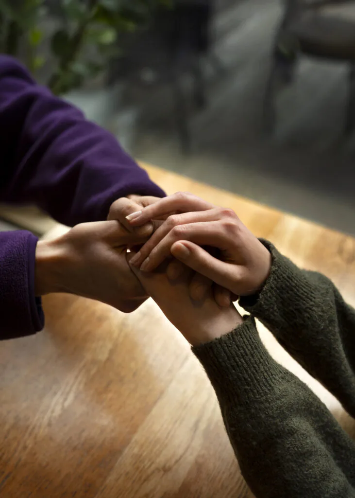 Mãos de duas pessoas segurando umas às outras